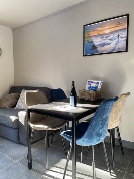 Gezellig eetgedeelte in Chalet Carpe Diem met uitzicht op de muur.