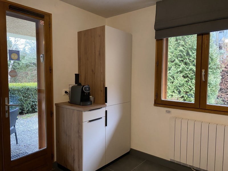 Knusse woonkamer met uitzicht op tuin en moderne keuken.