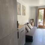 Gezellig interieur met bank, tv en uitzicht op tuin.