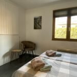 Knusse slaapkamer met bed en uitzicht op tuin in Gite Le Prégentil.