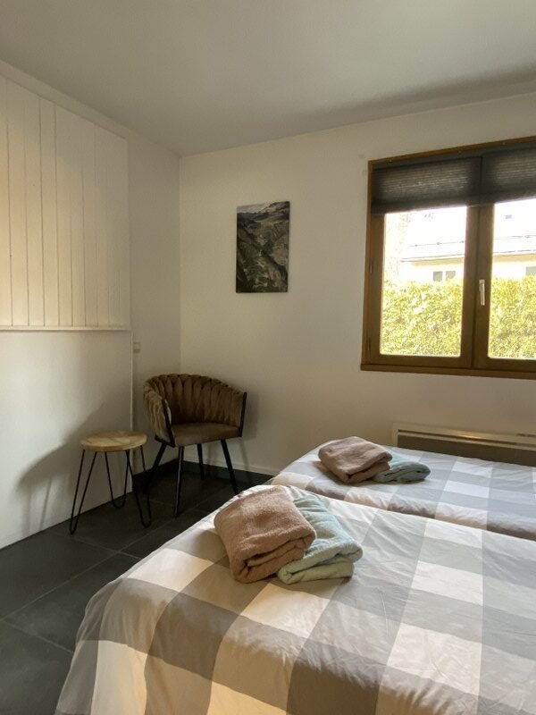 Knusse slaapkamer met bed en uitzicht op tuin in Gite Le Prégentil.