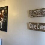 Binnenzicht van Chalet Carpe Diem met welkomstborden en kunstwerk.