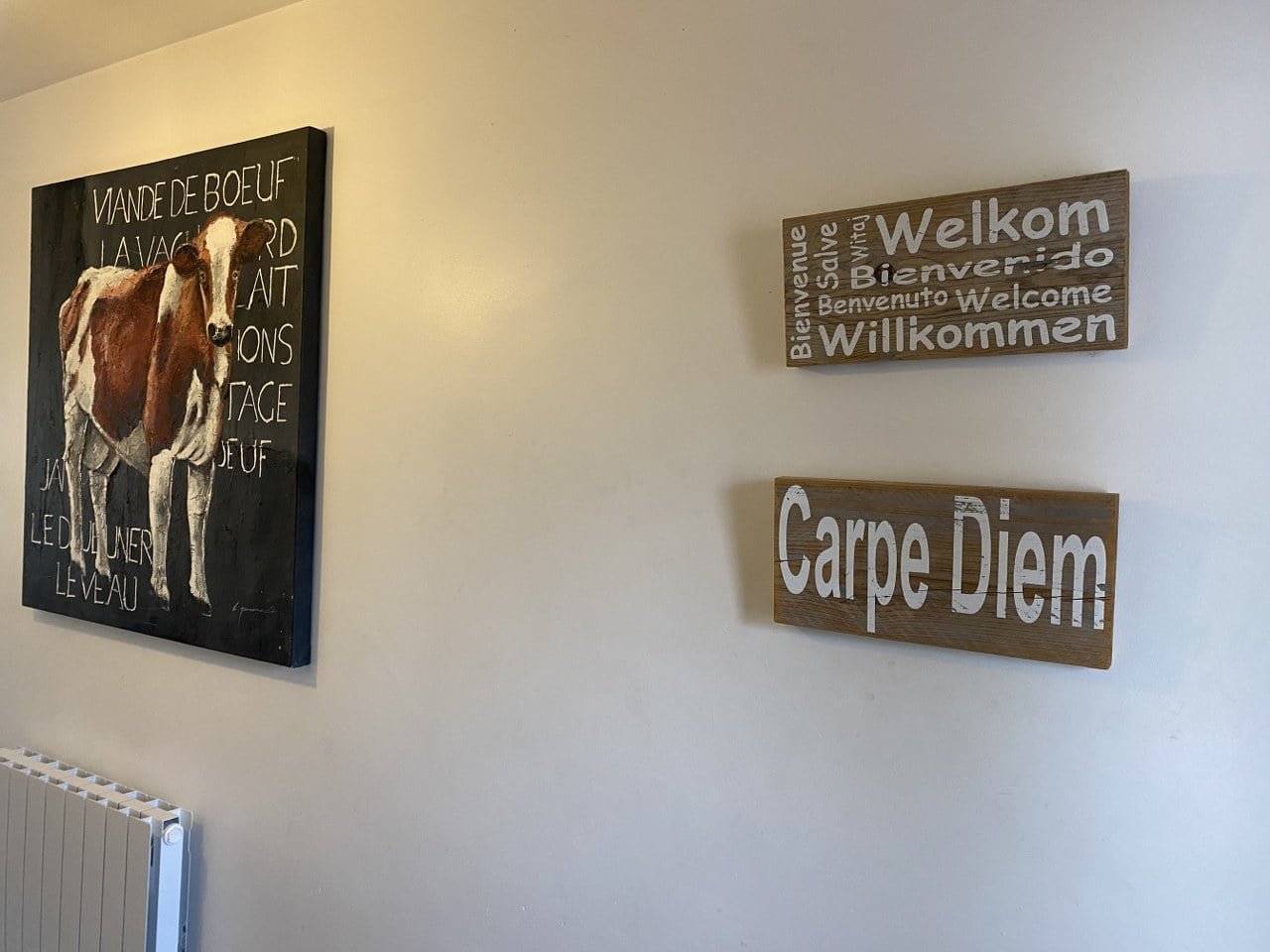 Binnenzicht van Chalet Carpe Diem met welkomstborden en kunstwerk.