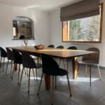Eethoek met grote tafel en uitzicht op bos in Chalet Carpe Diem.