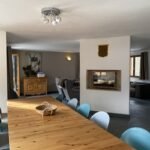 Gezellig interieur van chalet met houten tafel en moderne inrichting.