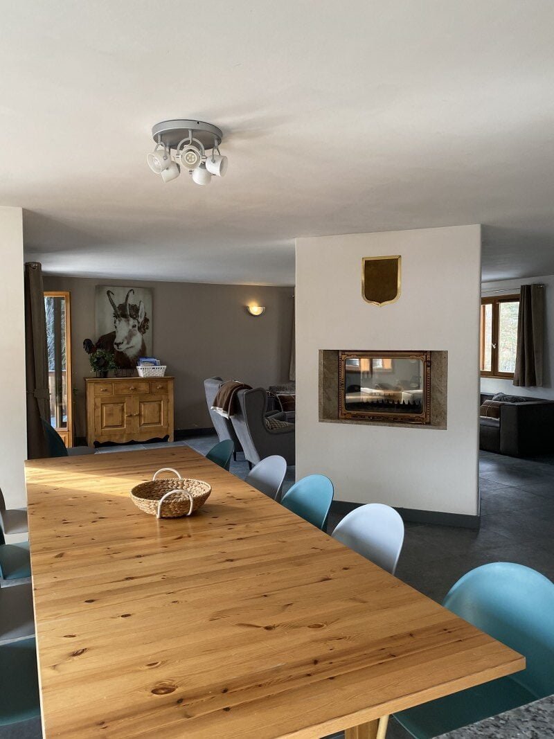 Gezellig interieur van chalet met houten tafel en moderne inrichting.