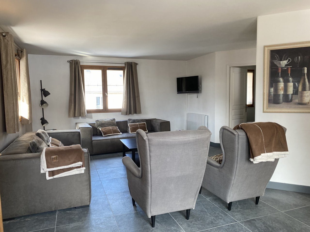 Gezellige woonkamer met comfortabele stoelen en tv in Chalet Carpe Diem.